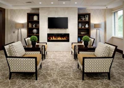 Common area with fireplace and multiple chairs, plants