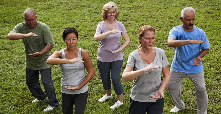 Group of seniors exercising outdoors at Jenner’s Pond independent living community